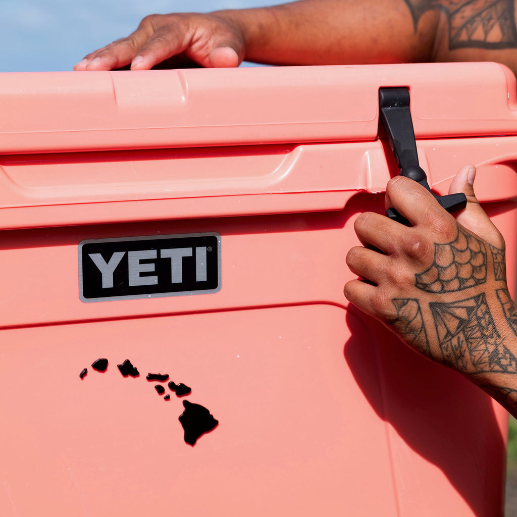 Person holding a pink cooler with Hawaiian Islands Chrome decal with a tattooed arm.